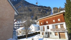 Un bâtiment en bois à deux étages, doté d’un balcon, entouré d’un paysage enneigé et d’arbres.