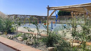 A playground with swings and climbing structures, surrounded by a garden with rocks and plants. - Apt 4 rooms, 8 ppl, pool, tennis, parking included - Port Barcarès (Port Barcarès)