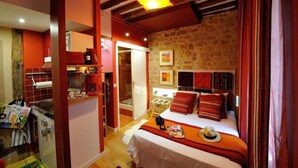 A cozy bedroom with a bed, a nightstand, a lamp, and a window. - D1GG Colorado (Paris)