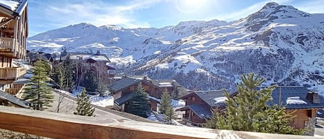 A mountain resort with wooden buildings and a wooden fence in the foreground.