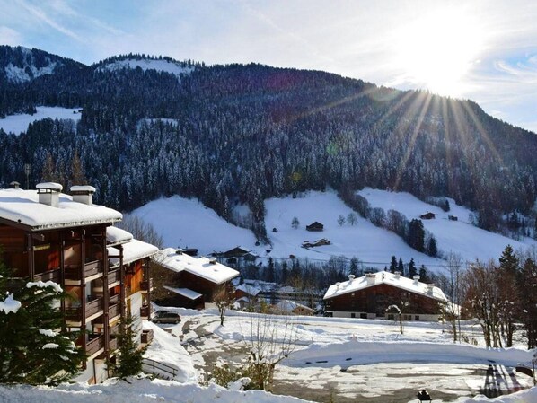 A snow-covered mountain landscape with a lodge featuring multiple buildings and a ski slope.