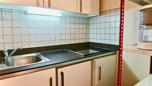 Una cocina con fregadero, estufa y armarios.