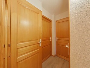 Corredor com portas de madeira e parede com textura.