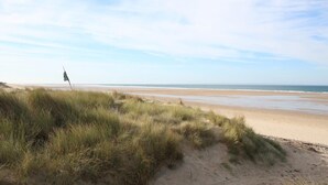 A beach with sand dunes and a flag. - Charming studio at the Manor with private garden and WiFi (Baubigny)