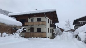 A multi-story building with balconies, surrounded by snow-covered ground and trees. - Triolets 1 - 3 bedroom apartment in the centre (MORZINE)