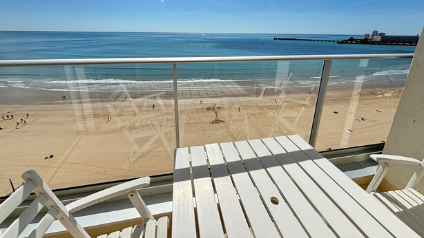 Ein Balkon mit Blick auf Strand und Meer.