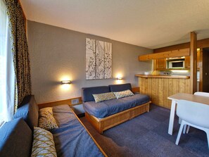 A compact room with a bed, a small table, and a kitchenette. - Ski-in/out studio for 5, Les Arcs 1800, pets allowed (Les Arcs 1800)