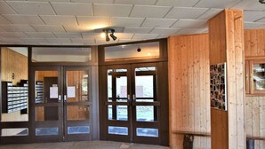 A reception area with wooden paneling, a stone floor, and a ceiling with recessed lighting. - Mountain Studio, 4 Sleeps, Ski-In/Ski-Out, Free Parking, Risoul 1850 (Risoul)