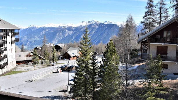 A mountain resort with a view of snow-capped peaks, wooden cabins, and a paved road. - Mountain Studio, 4 Sleeps, Ski-In/Ski-Out, Free Parking, Risoul 1850 (Risoul)