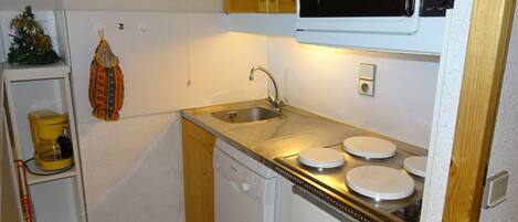 A compact kitchen with a microwave, sink, and dishwasher.