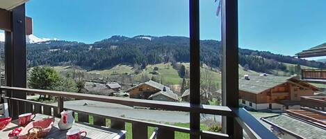 A balcony with a view of a village and mountains.