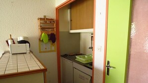 A compact kitchen with a small refrigerator, a sink, and a countertop with a dish rack. - Studio cabin for 4, covered parking, 50m from slopes (La Mongie)