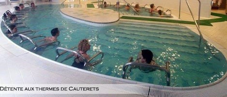 Una piscina interior con varias pistas y un área central para actividades acuáticas.