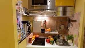 Une cuisine compacte équipée d’un four à micro-ondes, d’une bouilloire et d’un évier.