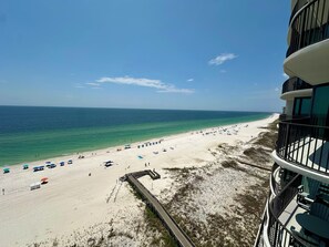 A beach view from a high-rise building with a clear sky, a sandy beach, and a wooden walkway. - 2 BR/2.5 BA Condo on the 10th Floor! In Walking Distance to Flora Bama! (Orange Beach)