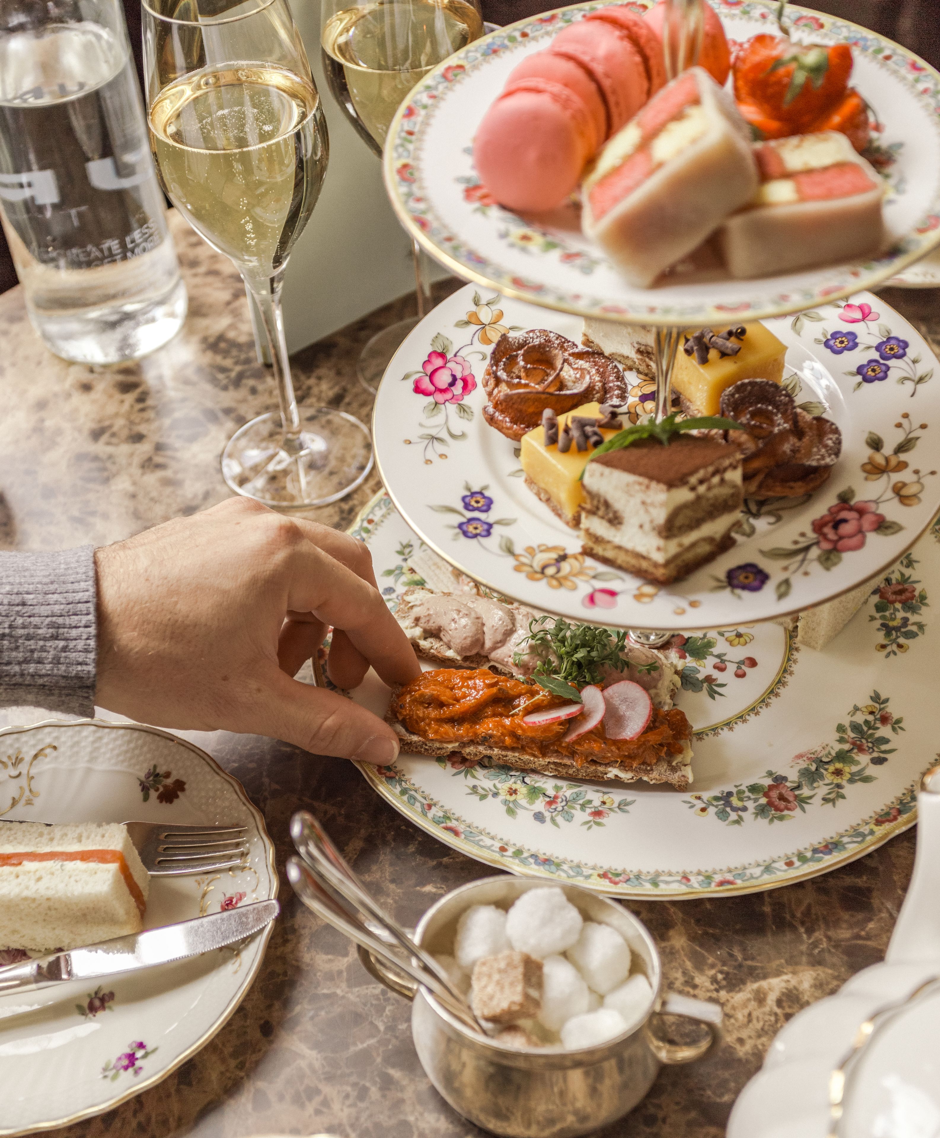 Une table avec divers desserts, un verre de vin et un bol de barbe à papa.