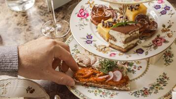 Une table avec divers desserts, un verre de vin et un bol de barbe à papa.