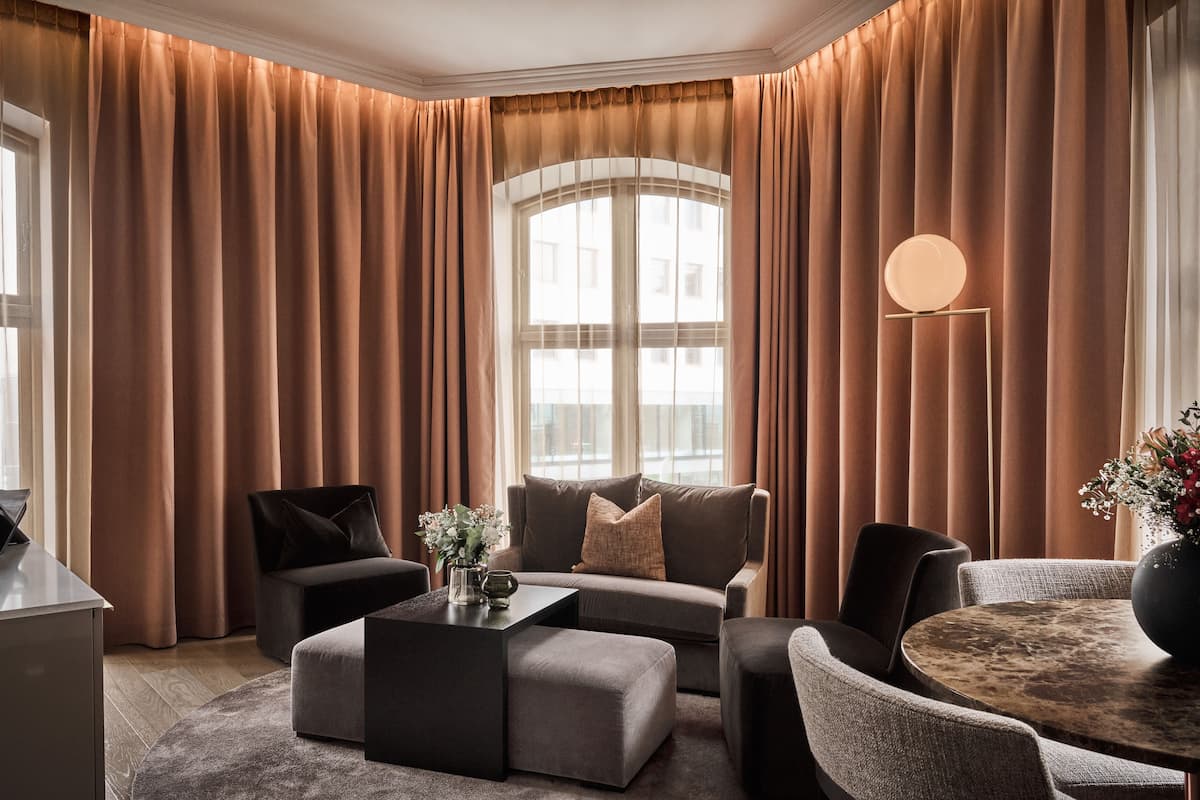 A modern living room with a sofa, ottoman, and round coffee table.