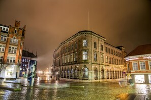 A historic building with a corner facade, large windows, and a flagpole.