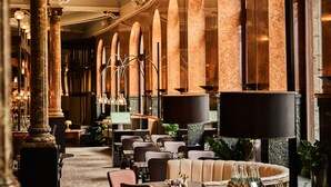 A spacious hotel lobby with high ceilings, arched windows, and a variety of seating arrangements including tables and sofas. - Opus XVI, a member of Small Luxury Hotels of The World (Bergen)