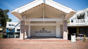 The entrance of The Village of Baytowe Wharf, featuring a brick facade and a white roof. - Sandestin Luau Studio, Steps to Beach - Family/Golf, Beach Gear/TRAM/WiFi (Miramar Beach)