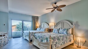 A bedroom with two beds, a ceiling fan, and a view of the outdoors. - Sandestin Luau Studio, Steps to Beach - Family/Golf, Beach Gear/TRAM/WiFi (Miramar Beach)