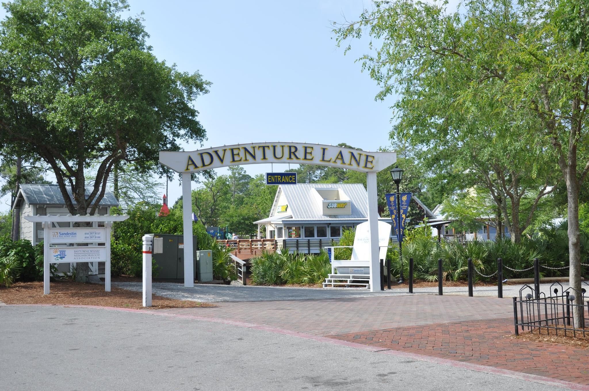 Et skilt med teksten "Adventure Lane", under hvilket der er en indgang til Subway.