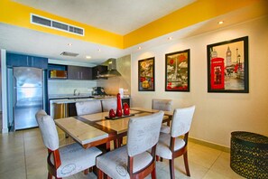 A dining area with a table set for six, surrounded by chairs with a patterned fabric.
