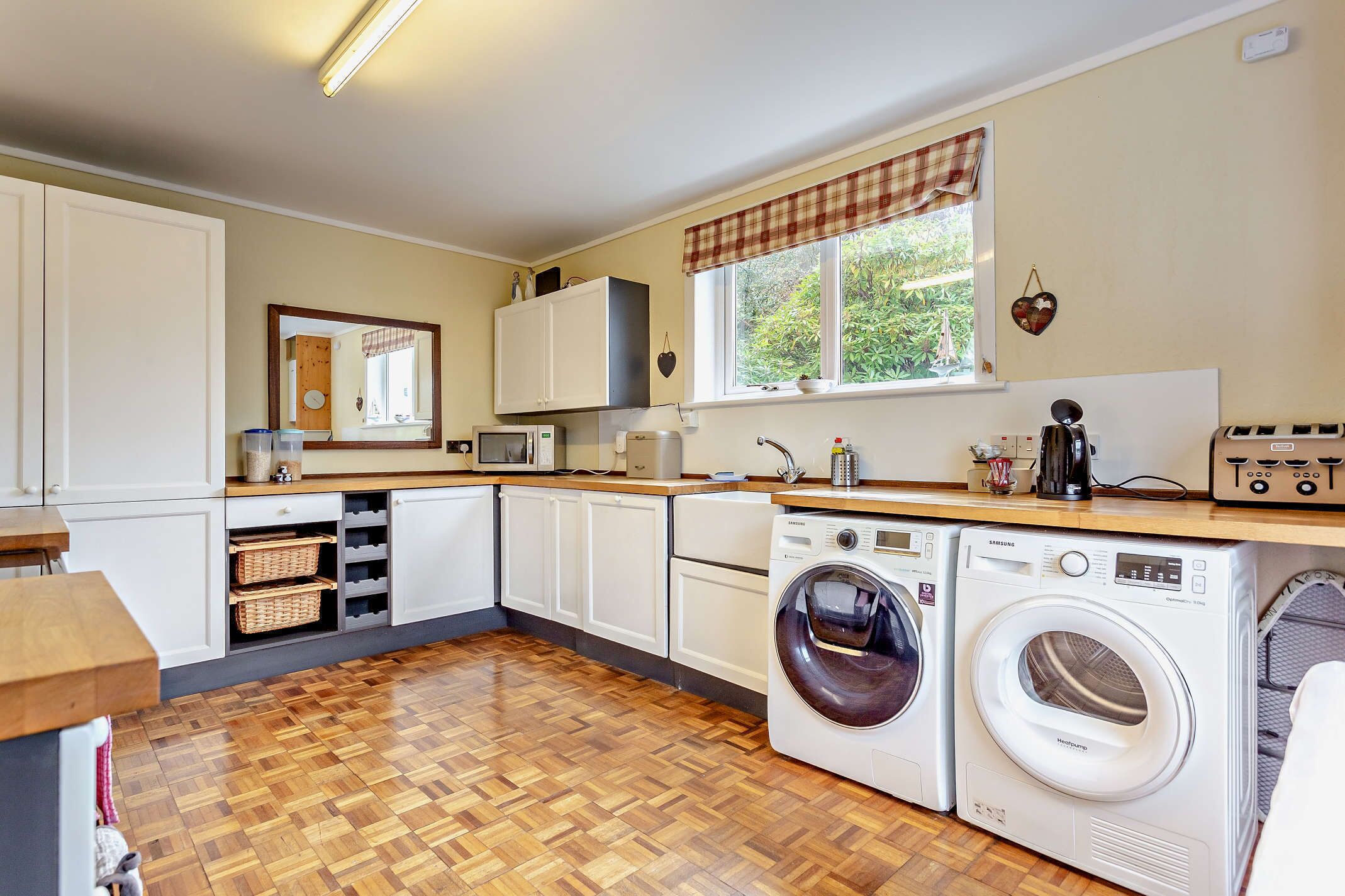 A compact kitchen with a washing machine, microwave, and cabinets.