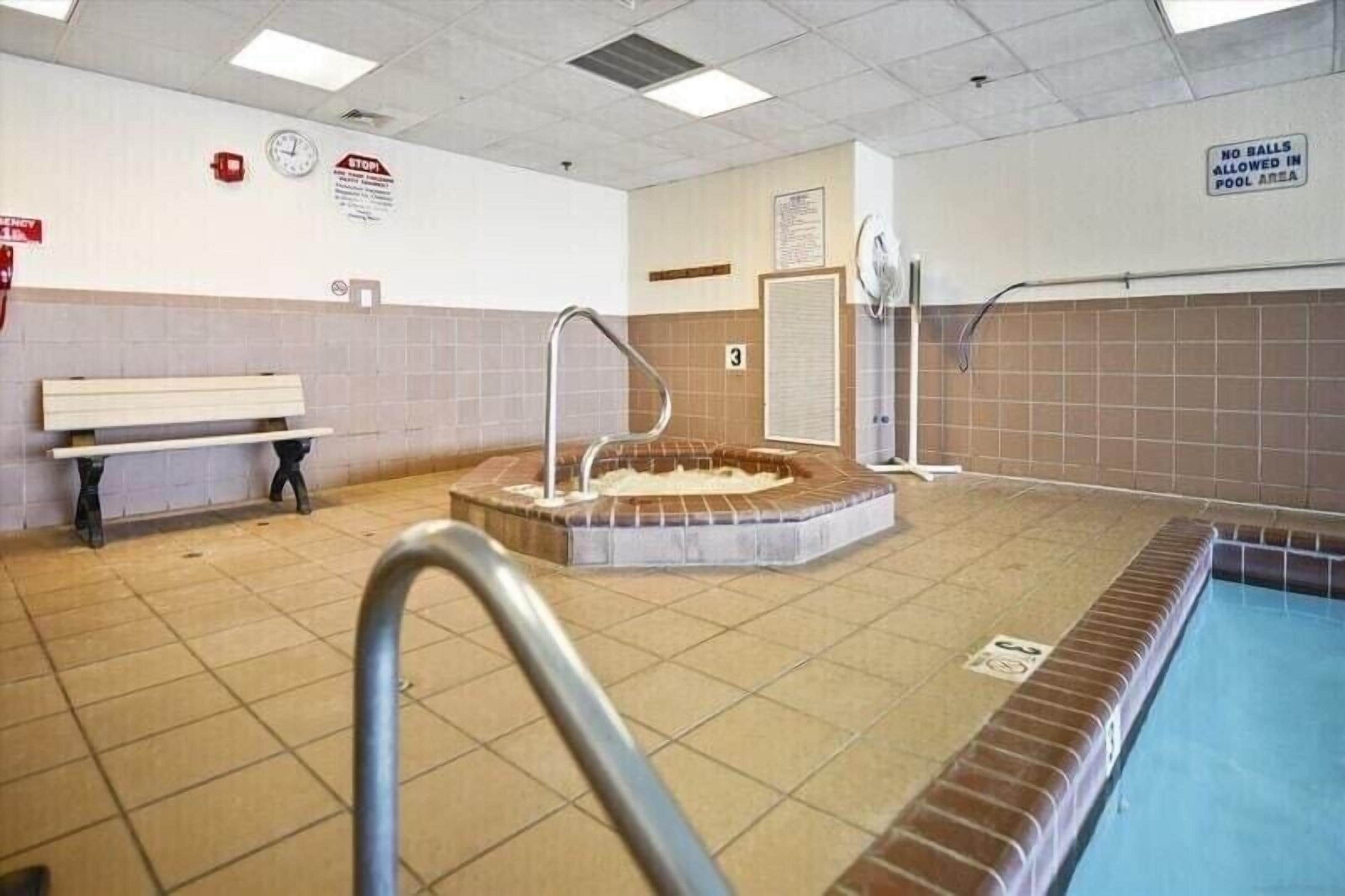 Ein Poolbereich mit Whirlpool, einer Sitzbank und einem Schild, das das Spielen mit Bällen im Poolbereich untersagt.