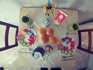 A dining table with food and drinks, surrounded by chairs.
