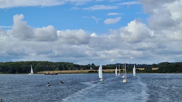 A lake with sailboats and a distant shoreline.