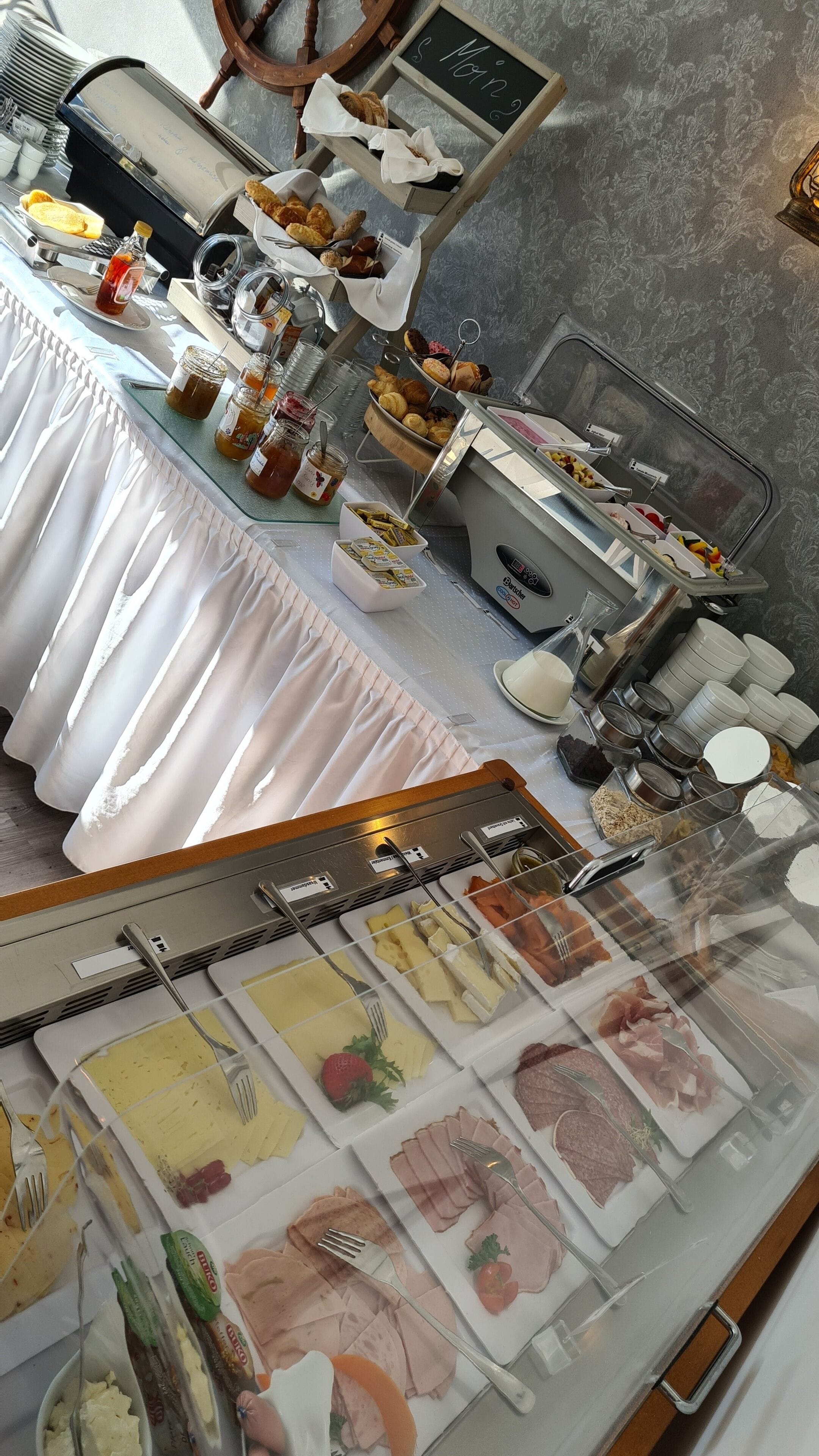Un dispositiu de buffet amb diversos plats, incloent pastissos, carns i condiments.