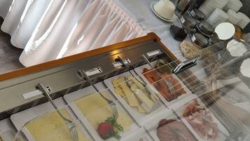 Un dispositiu de buffet amb diversos plats, incloent pastissos, carns i condiments.
