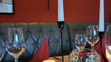 A table set with wine glasses, a candle, and a decorative bowl with flowers.