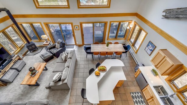 A spacious living area with a fireplace, sofa, and dining table. - Powder Moose Villa-Stunning Mountain Views from this Private Home with Hot Tub. (Breckenridge)