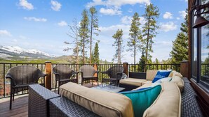 A deck with wicker furniture, including a sofa and chairs, overlooking a mountainous landscape. - Powder Moose Villa-Stunning Mountain Views from this Private Home with Hot Tub. (Breckenridge)