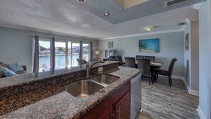 Una cocina moderna con encimeras de granito, fregaderos de acero inoxidable y un comedor con vistas.