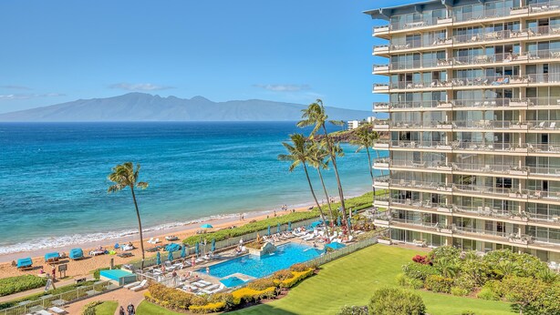 Un hôtel doté d’une piscine, offrant une vue sur la plage et comprenant plusieurs balcons.