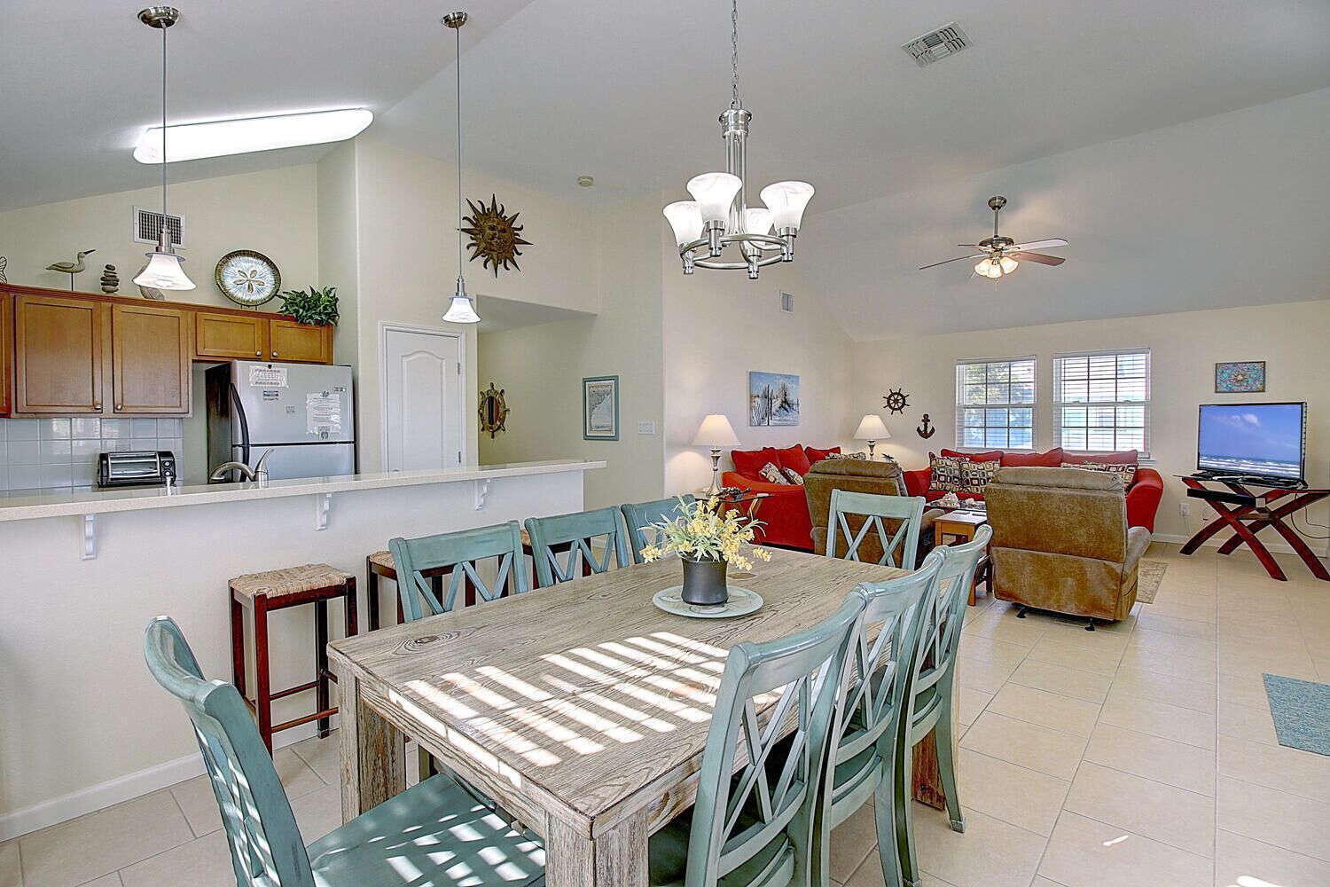 A spacious living area with a dining table, chairs, a sofa, and a TV.