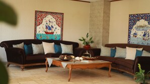 Una sala de estar tradicional con dos sofás, una mesa de centro y decoración en la pared.