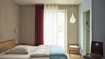 Una camera da letto con un letto, una sedia, una scrivania e una lampada a sospensione.