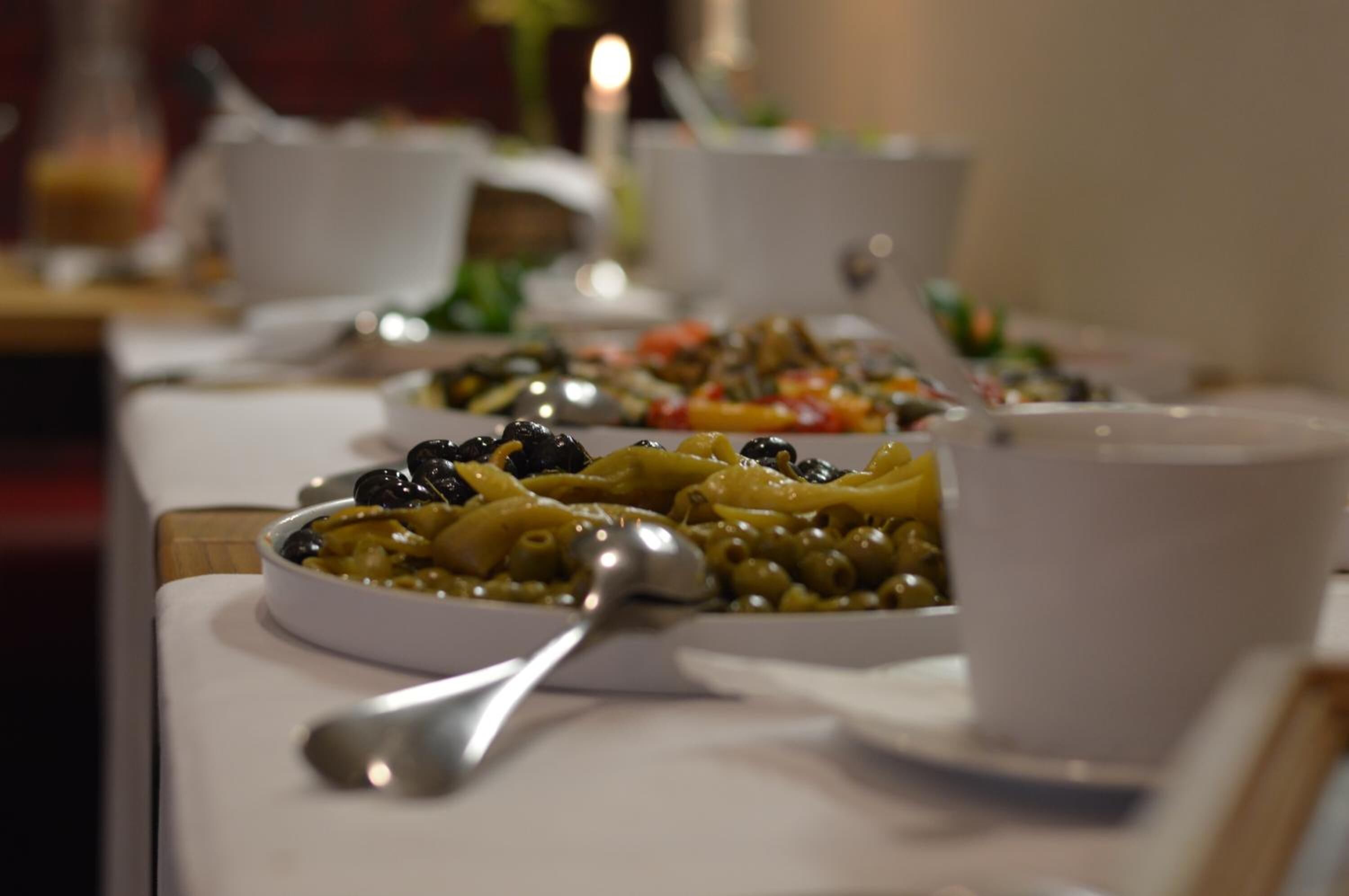 A dining table with various dishes and a spoon.
