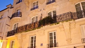 A historic building with ornate balconies and a shop entrance.