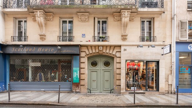 A building with a storefront labeled "Scotland House of Commerce" and a "Dollhouse" shop across the street.