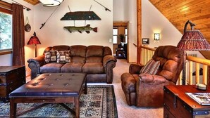Ein gemütliches Wohnzimmer mit Ledersofas, einem Couchtisch und einem Kamin.