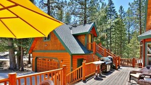 Eine Holzhütte mit einer Veranda, Sitzgelegenheiten im Freien und einer Treppe zum Eingang.