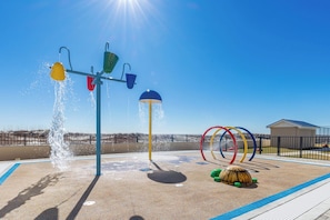A playground with water features and a turtle sculpture.