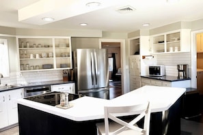 Fully equipped kitchen with island, open shelving, and modern appliances