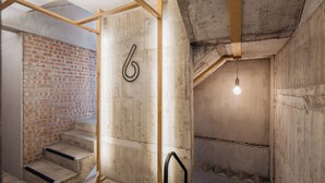 A staircase with a concrete wall and a wooden beam structure. - Just Inn - City Hall (Taipei)
